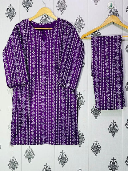 Purple patterned kurta with matching pants on a hanger against a decorative wall.
