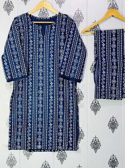 Blue and white patterned dress with matching pants on hangers against a decorative wall.