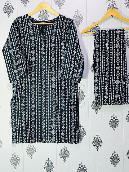 Black and white patterned garment on a hanger against a decorative wall.